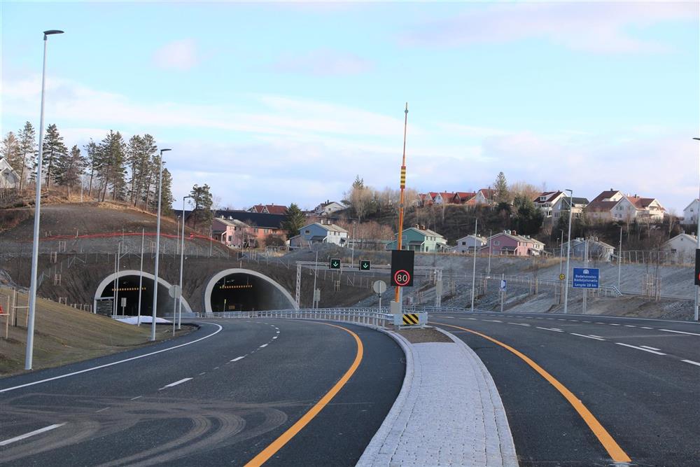 Forefelts vei mot to tunnelinnganger. Flere skilt. Boligområde.  - Klikk for stort bilde