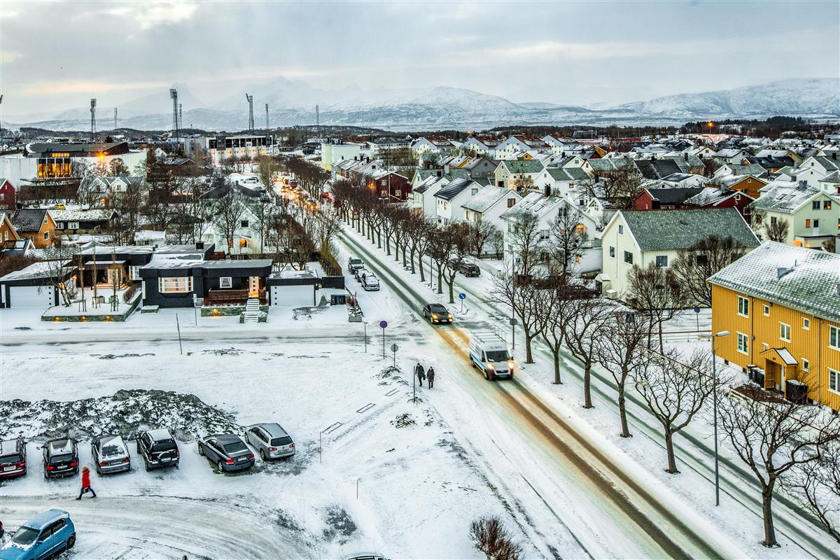 Oversiktsbilde av Hålogalandsgata sett ovenfra i retning Aspmyra fra fylkeshuset. Bakken er snødekt, biler kjører i gata folk går på fortauet.  - Klikk for stort bilde